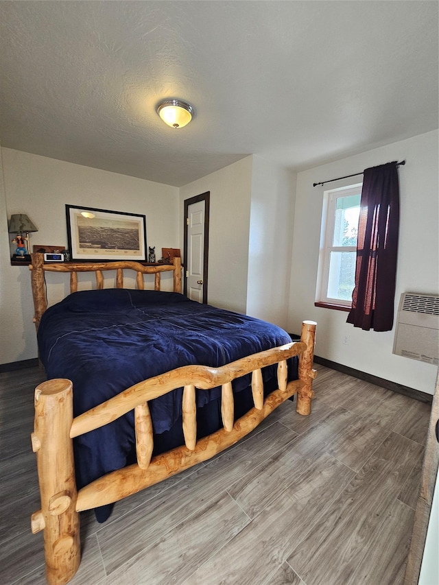 bedroom featuring wood-type flooring and a wall mounted AC