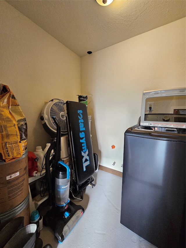 washroom featuring washer / clothes dryer and a textured ceiling