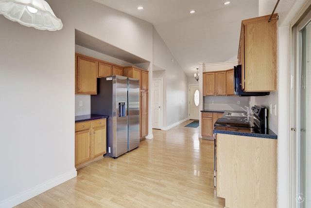 kitchen featuring high vaulted ceiling, light hardwood / wood-style flooring, stainless steel fridge, and sink