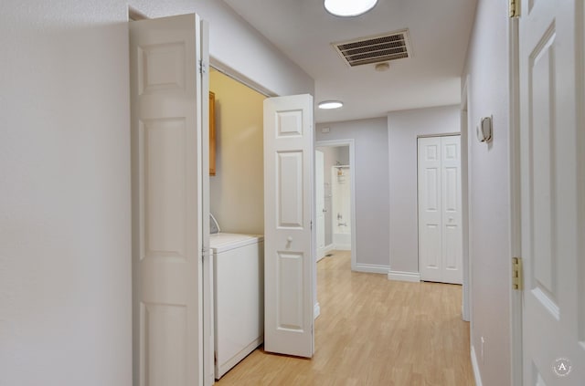 corridor featuring light hardwood / wood-style floors and washer / dryer