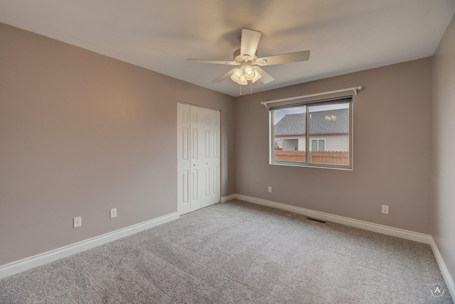 unfurnished bedroom with ceiling fan, a closet, and carpet floors