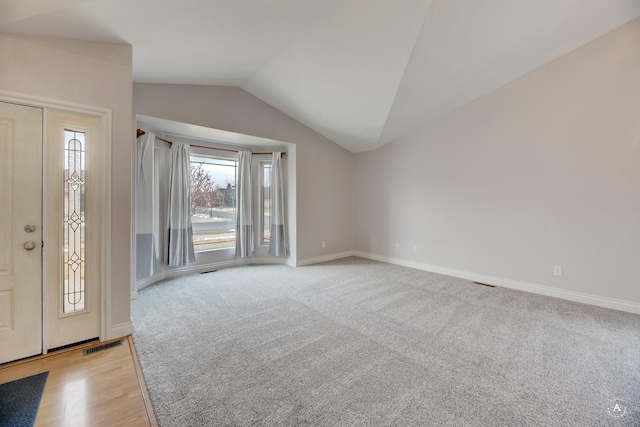 carpeted foyer entrance with lofted ceiling