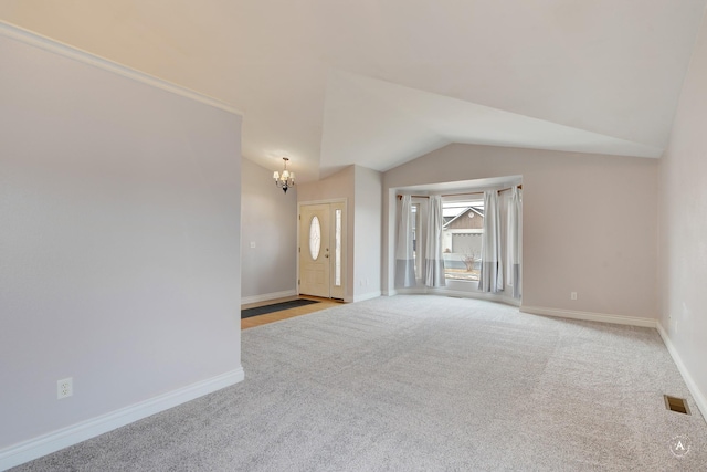 carpeted empty room with an inviting chandelier and vaulted ceiling