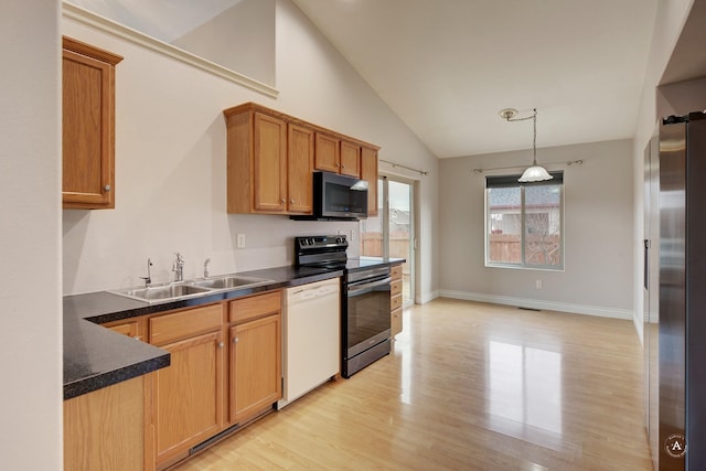 kitchen with lofted ceiling, stainless steel appliances, sink, hanging light fixtures, and light hardwood / wood-style flooring