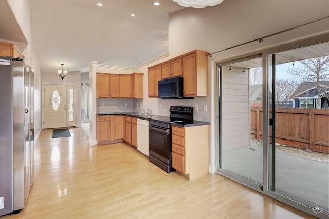 kitchen featuring an inviting chandelier, light hardwood / wood-style floors, hanging light fixtures, black appliances, and sink