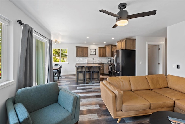 living room featuring a ceiling fan, recessed lighting, dark wood-style floors, and baseboards