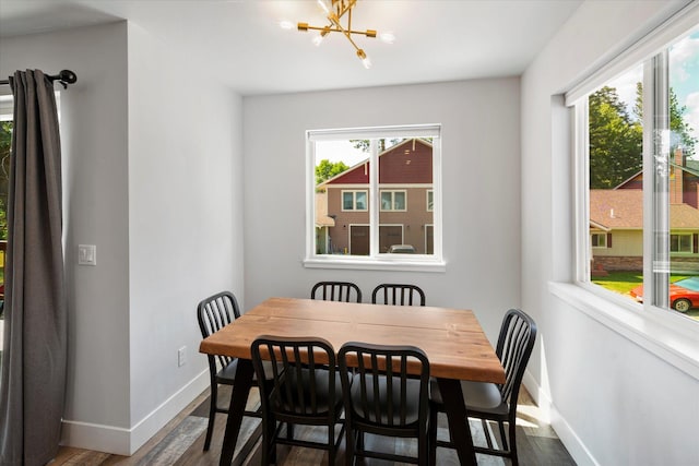 dining room featuring baseboards, dark wood-type flooring, and a chandelier