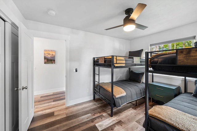 bedroom featuring ceiling fan, baseboards, and wood finished floors