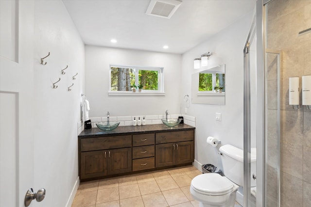 bathroom featuring tile patterned flooring, visible vents, a shower stall, baseboards, and toilet