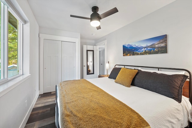 bedroom featuring dark wood finished floors, ceiling fan, a closet, and baseboards