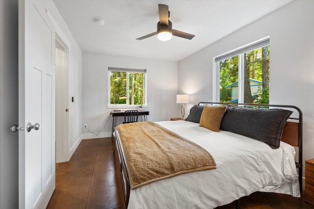 bedroom featuring a ceiling fan, concrete floors, and baseboards