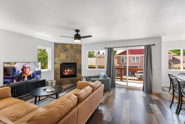 living room with a fireplace, a wealth of natural light, and ceiling fan