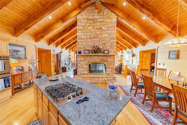 805 Georgetown Lake Rd, Anaconda, MT 59711 - living area with wooden ceiling with exposed beams, light wood-style floors, wood walls, a fireplace, and a ceiling fan