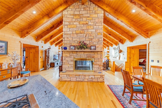 805 Georgetown Lake Rd, Anaconda, MT 59711 - living room with wood ceiling with exposed beams, wood walls, wood finished floors, a stone fireplace, and high vaulted ceiling