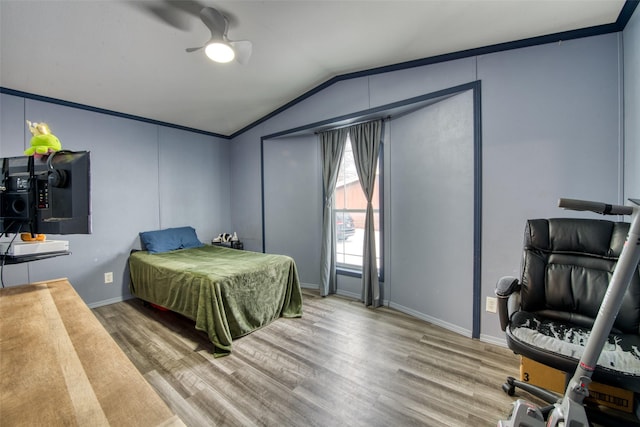 bedroom featuring ceiling fan, ornamental molding, lofted ceiling, and wood-type flooring