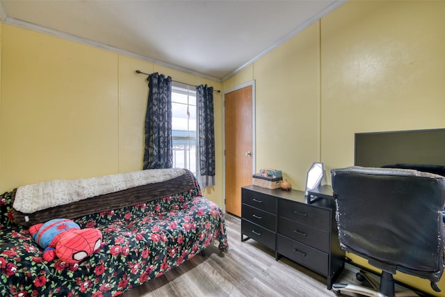 bedroom with light hardwood / wood-style floors and ornamental molding