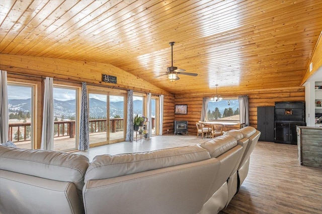 living room featuring ceiling fan, log walls, a mountain view, lofted ceiling, and wood ceiling