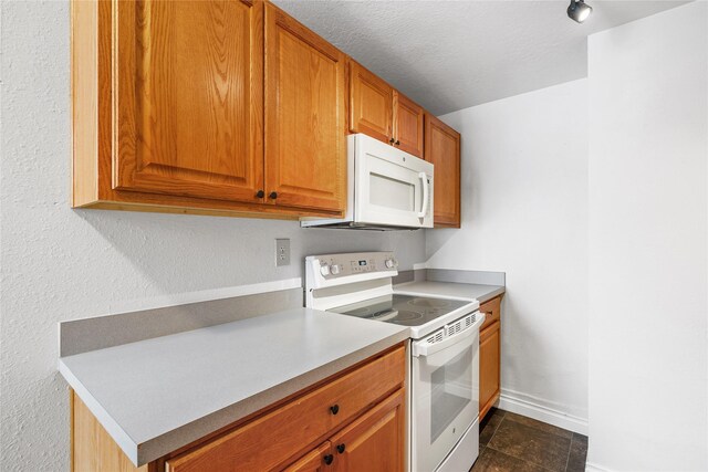 kitchen with sink, rail lighting, and white appliances