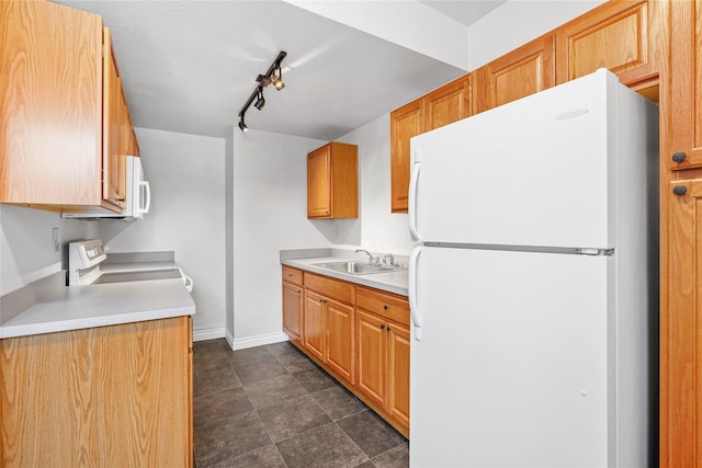 kitchen with white appliances, rail lighting, and sink