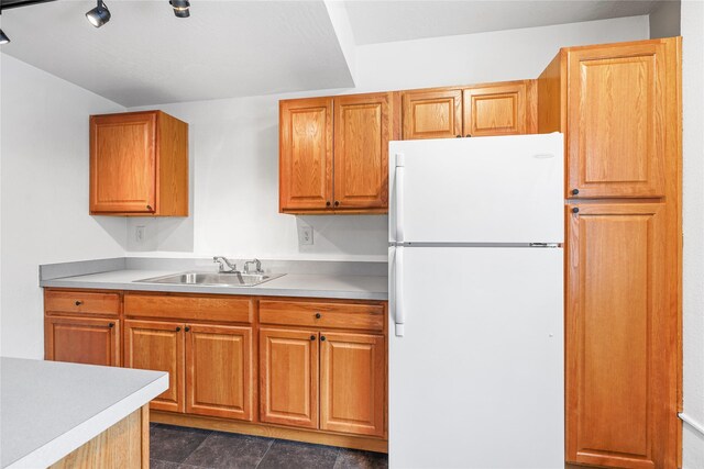 kitchen with a textured ceiling, white appliances, sink, and track lighting