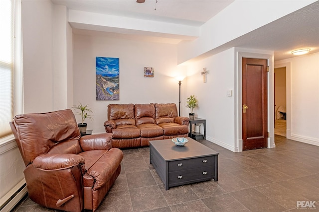 living room featuring beamed ceiling, a baseboard heating unit, and ceiling fan