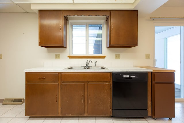 kitchen with dishwasher, light tile patterned floors, and sink