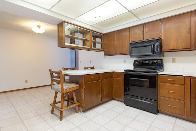 kitchen with black appliances, a kitchen breakfast bar, and kitchen peninsula