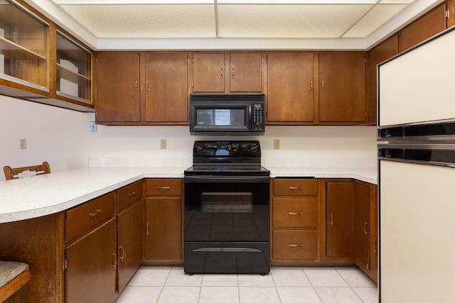 kitchen with light tile patterned floors and black appliances