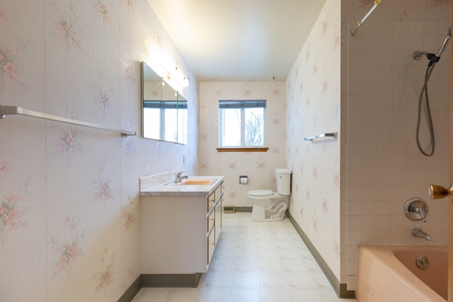 full bathroom featuring vanity, tiled shower / bath combo, and toilet