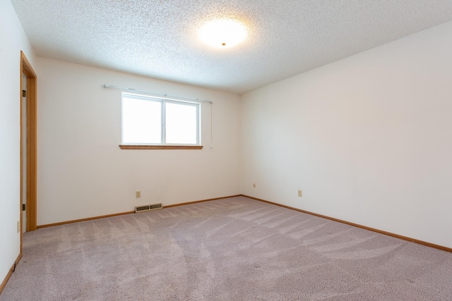 unfurnished room with light carpet and a textured ceiling