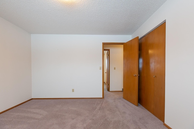 empty room featuring light colored carpet and a textured ceiling