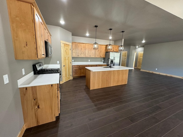 kitchen featuring sink, dark wood-type flooring, an island with sink, pendant lighting, and appliances with stainless steel finishes