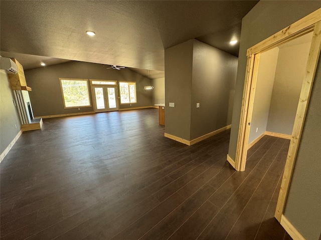 unfurnished room with ceiling fan, a wall mounted air conditioner, dark hardwood / wood-style flooring, a textured ceiling, and lofted ceiling