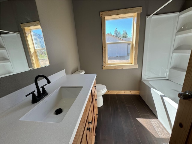 full bathroom with hardwood / wood-style floors, vanity, toilet, and shower / washtub combination