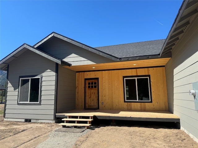 view of exterior entry with a wooden deck