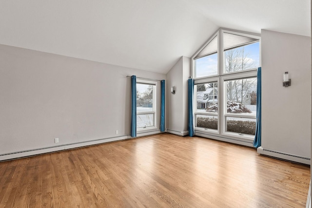 spare room featuring a baseboard radiator, lofted ceiling, and light hardwood / wood-style floors