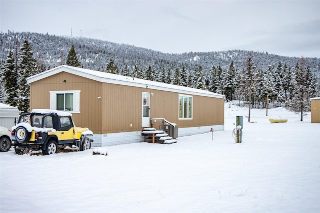 snow covered house featuring a mountain view