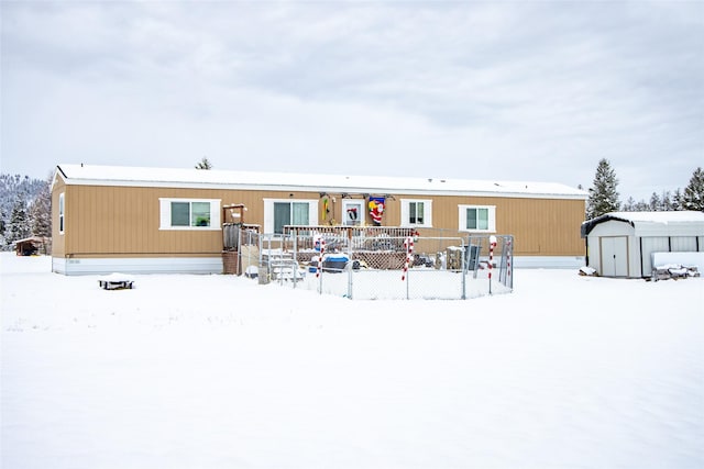 snow covered house featuring a shed