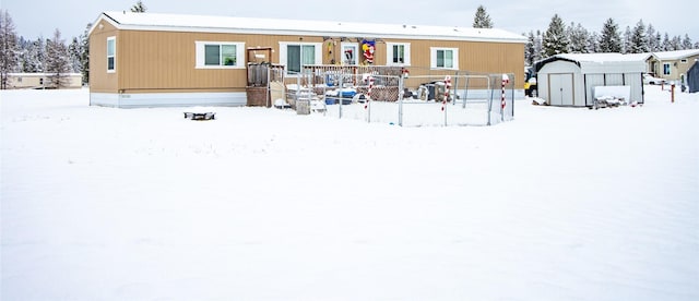 snow covered property featuring a storage unit