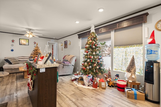 rec room featuring ceiling fan, light hardwood / wood-style flooring, and ornamental molding