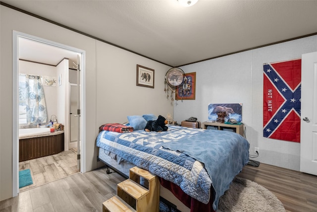 bedroom with hardwood / wood-style flooring and crown molding