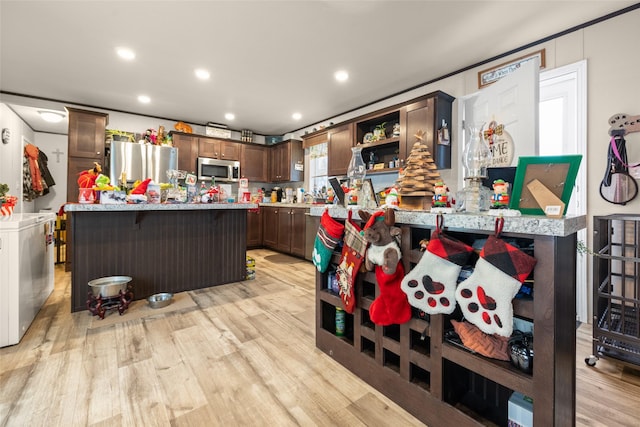 kitchen with a breakfast bar, appliances with stainless steel finishes, and dark brown cabinetry