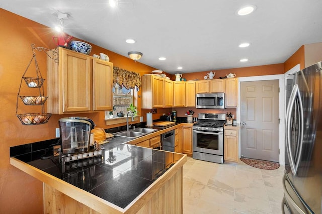 kitchen with light brown cabinetry, kitchen peninsula, sink, and stainless steel appliances