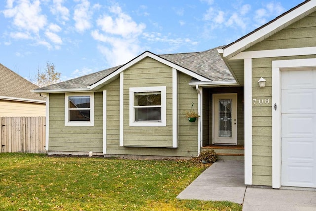 property entrance with a lawn and a garage