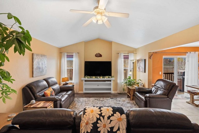 tiled living room with ceiling fan, a healthy amount of sunlight, and lofted ceiling