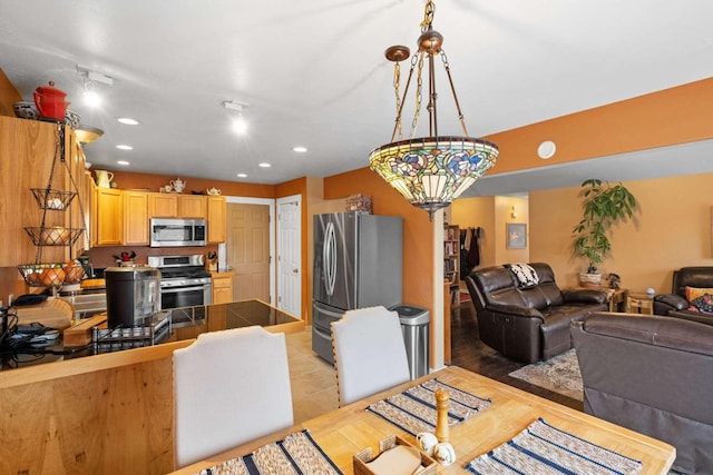 kitchen featuring light tile patterned floors, stainless steel appliances, and decorative light fixtures