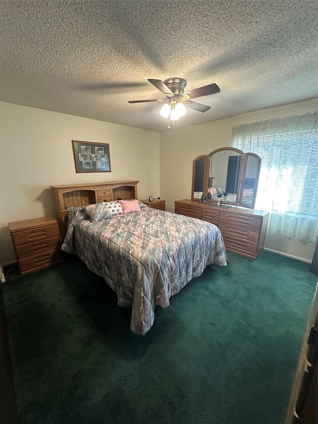 bedroom featuring a textured ceiling, dark carpet, and ceiling fan