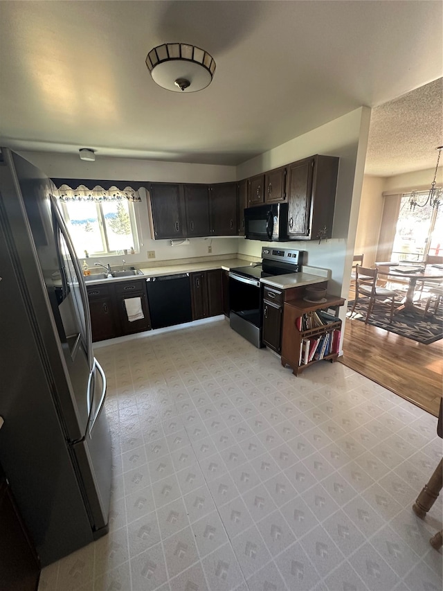 kitchen featuring dark brown cabinets, black appliances, and sink