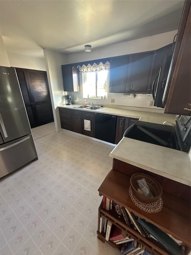 kitchen with dishwasher, stove, stainless steel refrigerator, and sink