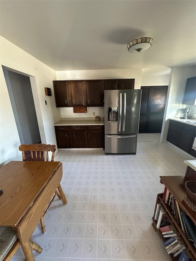 kitchen featuring dark brown cabinetry and stainless steel fridge with ice dispenser